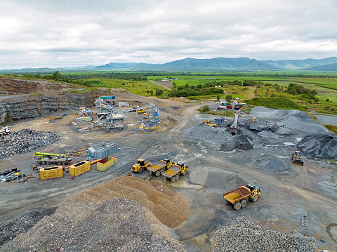 Mackay, Queensland, Australia - May 2022: Infrastructure and the machinery working in a quarry producing industrial rock and stone for construction of roads and other purposes.
