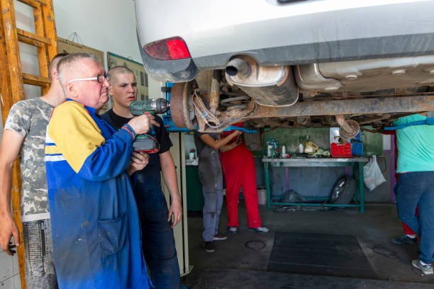 istock Male tutor with students on auto mechanic apprenticeship course at college 1400907285