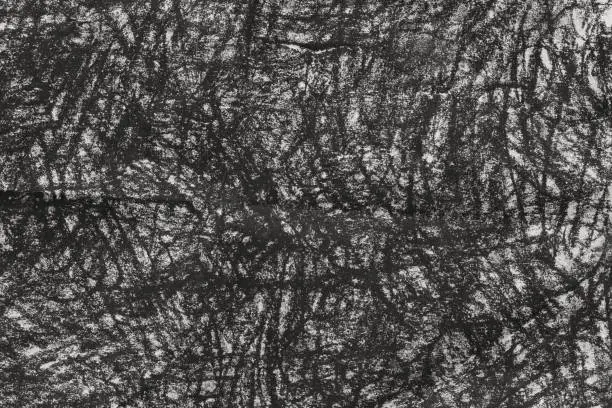 Photo of charcoal doodles on gray paper background texture