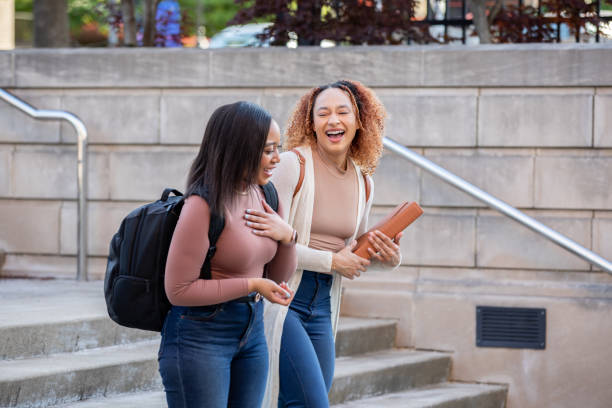 istock Happy university students talk while walking together on modern college campus 1400920842