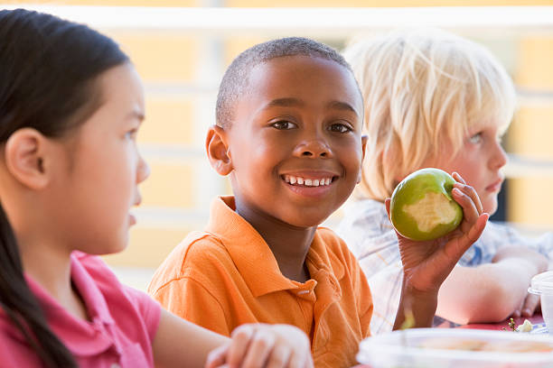 幼稚園児お子様のお食事 - child eating apple fruit ストックフォトと画像