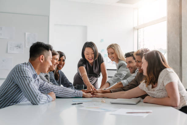 Korean mature businesswoman leads multiracial group of work colleagues in team building and agreement positive emotion in brainstorming planning session together in modern office meeting daytime la empresaria madura coreana lidera un grupo multirracial de colegas de trabajo en la formación de equipos y el acuerdo de emociones positivas en la sesión de planificación de lluvia de ideas juntos en la reunión de oficina moderna durante el día