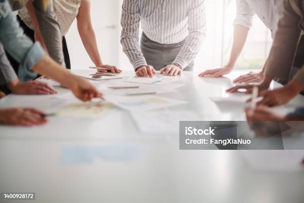 Low Angle View Of Hands Of Multiracial Group Of People Working With Ideas And Brainstorming Together To Make Decisions With Documents On Table In Creative Office Teamwork Stock Photo - Download Image Now