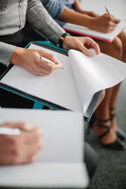 istock View of hands of people making notes while attending education seminar together 1400928191