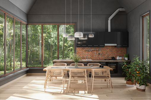 Interior de cocina moderna con mesa de comedor de madera, sillas y gabinetes negros photo