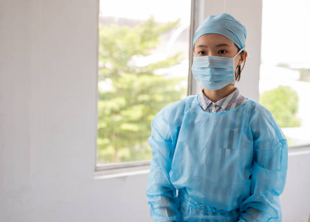 retrato de una cirujana asiática con exfoliantes y máscara facial protectora en el hospital - hair net nurse scrubs asian ethnicity fotografías e imágenes de stock