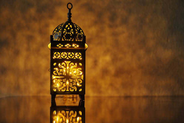 istock Ornamental Arabic lantern with burning candle glowing at night. 1400932088