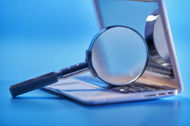 istock close up of magnifying glass with small laptop 1400932154