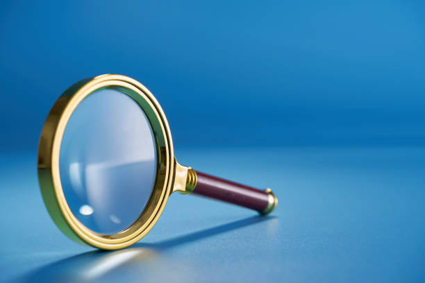 istock gold colored frame of magnifying glass wth red handle against blue background 1400932170