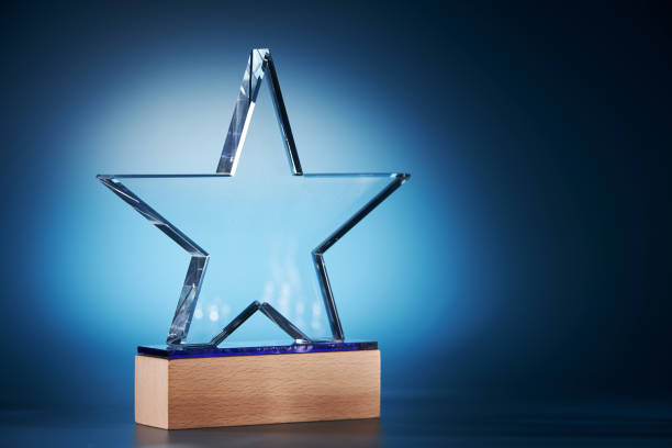 trophée en forme d’étoile de cristal sur fond bleu - champion sportif photos et images de collection