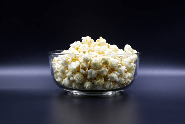 istock Popcorn in a glass cup placed on black background. 1400933338