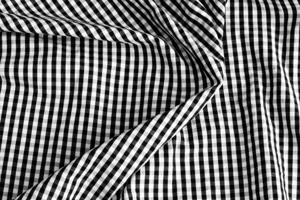 istock Texture of fabric in a cage. Black and white checked fabric. 1400943678