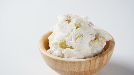 Sweet cottage cheese with raisins for breakfast in a wooden bowl