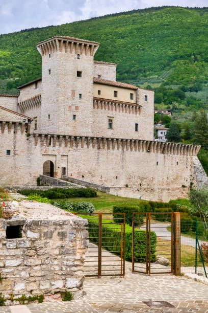 The imposing Rocca Flea castle in the medieval town of Gualdo Tadino in Umbria Gualdo Tadino, Italy, May 18 -- An idyllic view of the imposing Rocca Flea Castle of Gualdo Tadino, a medieval town between Spoleto and Gubbio, in the Italian region of Umbria. The Rocca Flea is a fortified building built in the 12th century by Emperor Frederick II of Swabia in 1242. Perfectly preserved, it is currently owned by the Municipality of Gualdo Tadino and inside it is possible to admire an antiquarium and the historic ceramics of Gualdo. An important city since Roman times, Gualdo Tadino rises along the ancient consular Via Salaria, traced by the Romans. Its history runs throughout the Middle Ages and, despite having been partially destroyed and sacked numerous times and placed under the dominion of Perugia, this ancient Umbrian center still retains its medieval charm. The Umbria region, considered the green lung of Italy for its wooded mountains, is characterized by a perfect integration between nature and the presence of man, in a context of environmental sustainability and healthy life. In addition to its immense artistic and historical heritage, Umbria is famous for its food and wine production and for the quality of the olive oil produced in these lands. Image in high definition format. gualdo tadino stock pictures, royalty-free photos & images