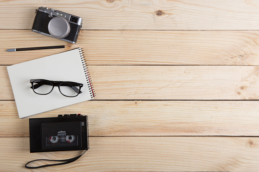 Writer, journalist or traveler desk - tape recorder, notepad and photo camera on the wooden background