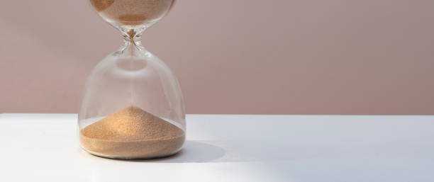 istock sand watch on wooden table. 1400952252