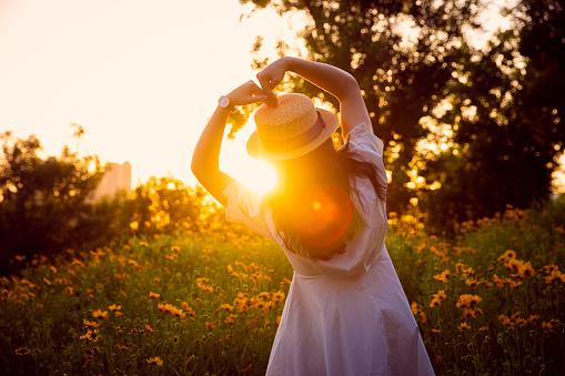 women hands making heart shape against the sunset