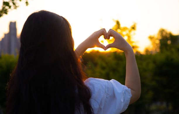 istock women hands making heart shape against the sunset 1400957659