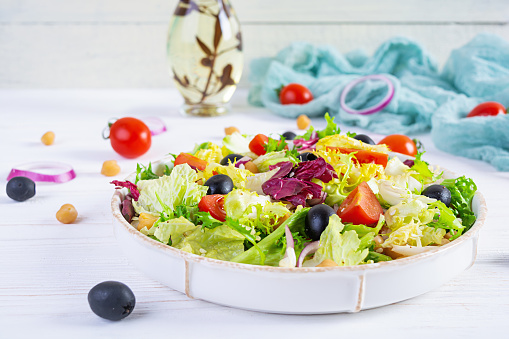 Vegetarian salad with chickpeas, tomatoes, olives and lettuce. Diet salad food