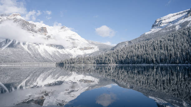 still alpine lake reflecting its winter surroundings like a mirror, wide, yoho n. park, canada - british columbia canada lake emerald lake imagens e fotografias de stock