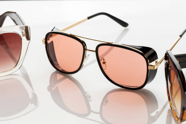 istock Sunglasses on a white reflective surface. Fashionable, stylish accessories. Use it for a vacation or summer concept. 1400959676