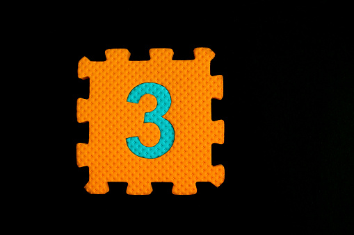 Colorful number puzzle isolated on black background. Number learning block for children education.