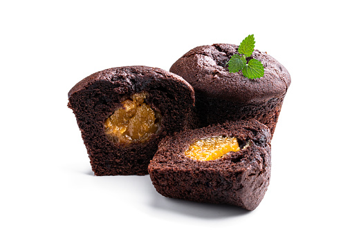 Dark  chocolate muffin stuffed with yellow jam isolated on white