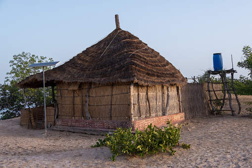 Sine-Saloum, Senegal - June 25, 2019: Hut with solar panel and water drum on the island of Sipo in the Saloum Delta