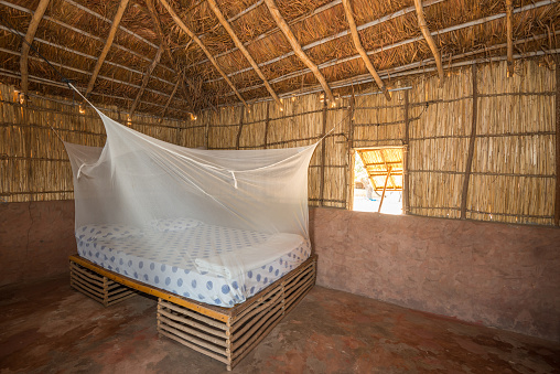 Sine-Saloum, Senegal - June 25, 2019: Bed with mosquito net in a hut in the Saloum Delta