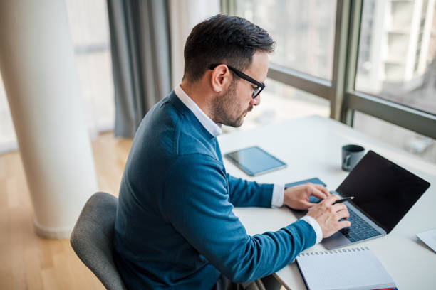 istock High angle view of serious businessman using laptop while planning at office 1400967248