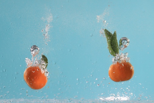 High-speed photography. Close-up of oranges in splashing water.