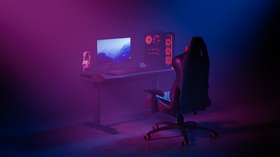 Gamer computer and equipments on the gaming desk under the neon colored spotlights.