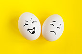 istock Two white eggs on yellow background concept. Emotions laughter and sadness. Friendship, relationship concept 1400972176