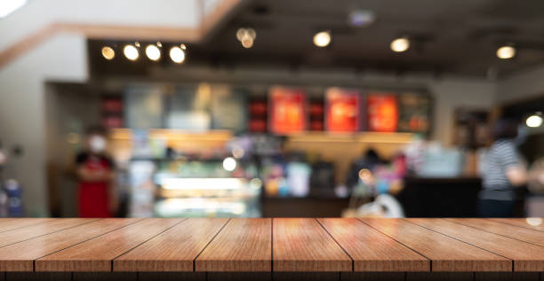 mesa de madera vacía con luces bokeh en el fondo borroso del restaurante - focus on foreground selective focus focus household equipment fotografías e imágenes de stock