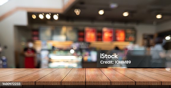 istock Empty wooden table top with lights bokeh on blur restaurant background 1400972233