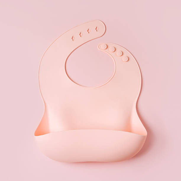 istock Pale Pink silicone baby bib. First baby accessories for dinner. Top view, flat lay 1400973998