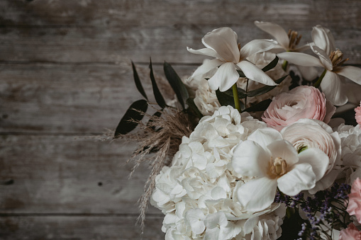 Beautiful bouquet of flowers against wooden background. Vintage styled.