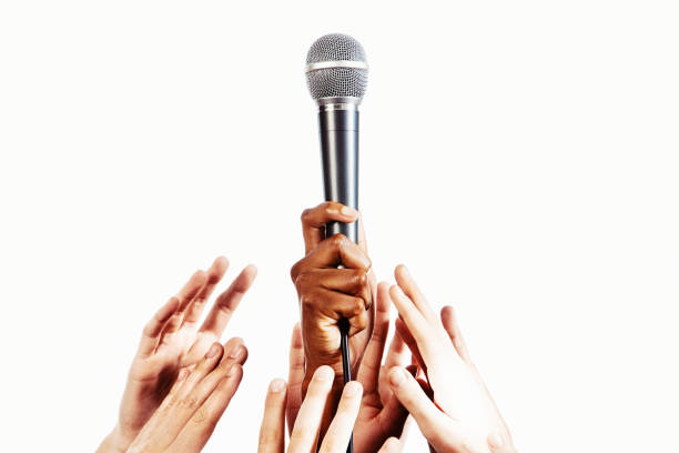 ¡queremos ser escuchados! manos diversas que buscan un micrófono brillante - talent show audio fotografías e imágenes de stock