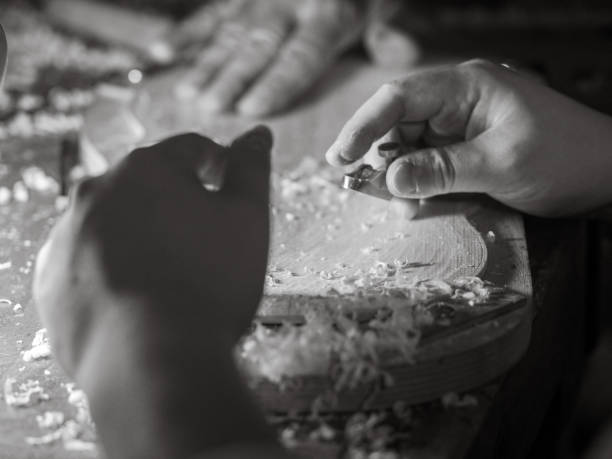 istock violin maker carving violin plate with thumb plane in the workshop with dim light 1400979784