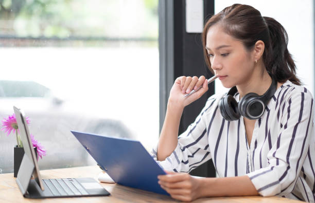 istock asian woman young wearing headset, communicating with client via video computer call. 1400980062