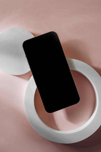 istock Smartphone with blank black screen. Mobile phone with a round geometric shape. Device screen mockup on minimal background for presentation or application design show. 1400985945