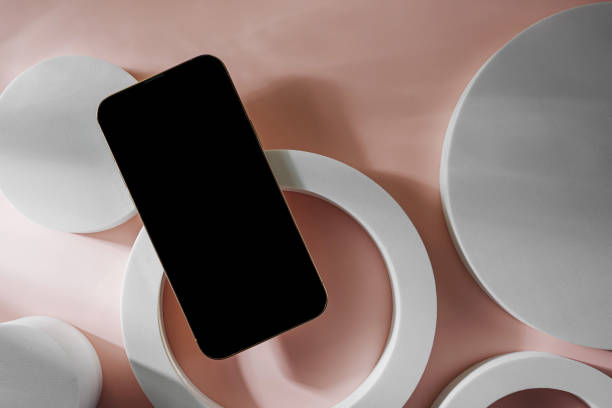 istock Smartphone with blank black screen. Mobile phone with a round geometric shape. Device screen mockup on minimal background for presentation or application design show. 1400985946