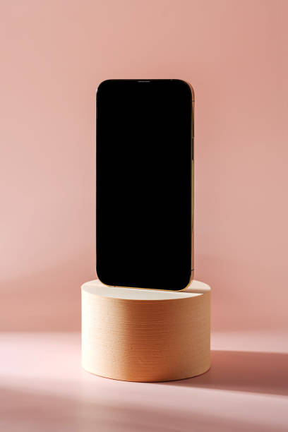 Smartphone with blank black screen. Mobile phone on cylinder podium.  Pedestal mockup space for display of app.