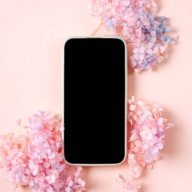 istock Smartphone mockup with pink flowers on pastel background. Device screen mock up on stylish background for presentation or appl design 1400986064