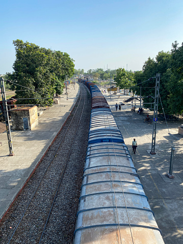 Bijnor, Uttar Pradesh, India - May 3, 2020:  Stock photo showing rail track line and gravel, metal railroad track at Bijnor railway station with freight train carrying coal.