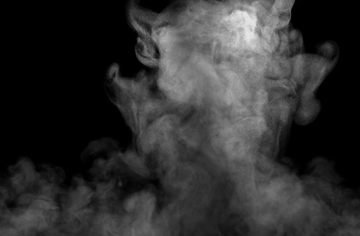 Close-up of white steam, fog or smoke effect. with visible water droplets abstract floating above isolated on a black background