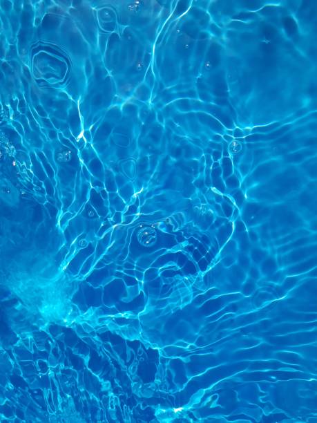 istock Defocus blurred transparent blue colored clear calm water surface texture with splashes and bubbles. Trendy abstract nature background. Water waves in sunlight. 1400988407