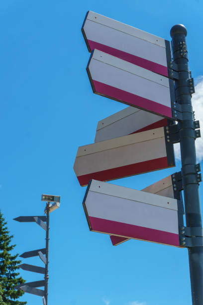 istock Blank directional road signs against blue sky. Directional sign post. Blue background. 1400988428