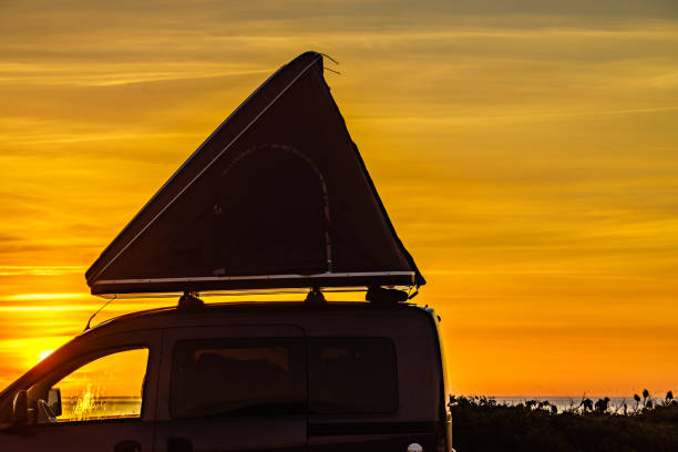 istock Car with roof top tent camp on beach 1400989754