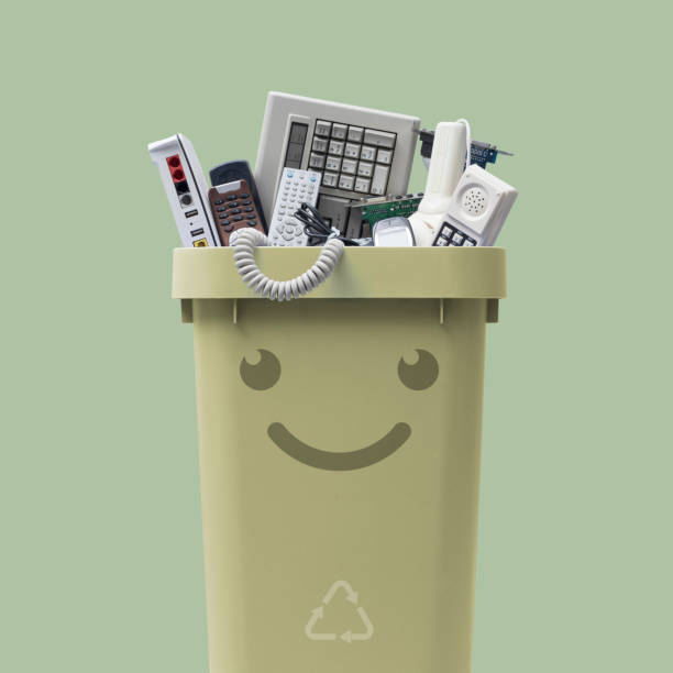 Smiling waste bin full of e-waste stock photo